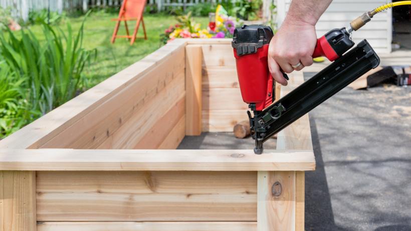 Brad nailer vs finish nailer - Closeup of a handyperson using a finish nailer on a woodworking project