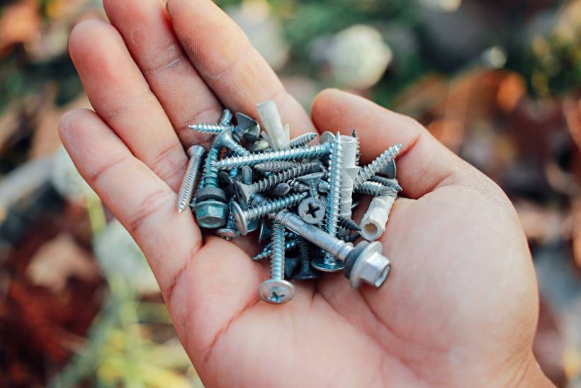 screw vs. bolt - a person holding screws and bolts