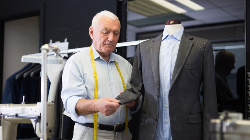 Seamstress vs tailor - A tailor measuring a new suit on a mannequin in a workshop