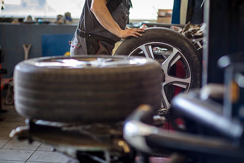 wheel balancing vs alignment - a man with wheel balancing equipment