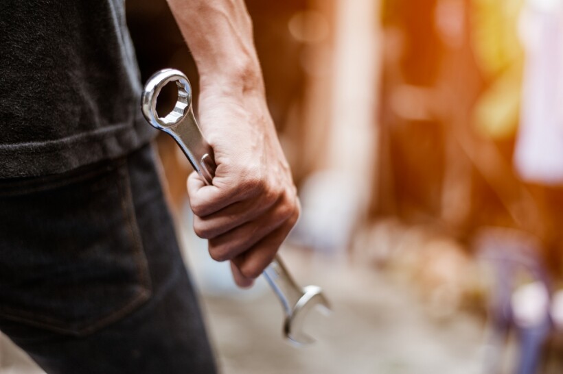 Spanner vs wrench - A man holding a spanner for a repair project.