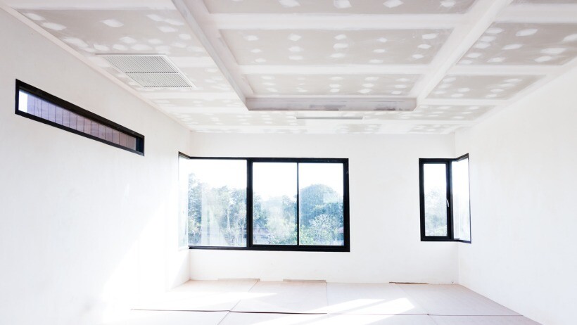 Plastering vs skimming - An empty room undergoing construction with a gypsum board ceiling in place