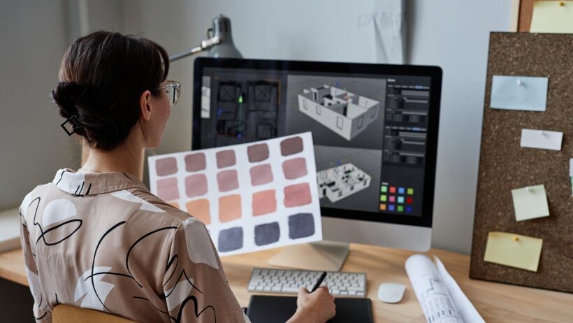 Interior design vs interior decorating - Interior decorator holding color swatches and looking at a computer screen