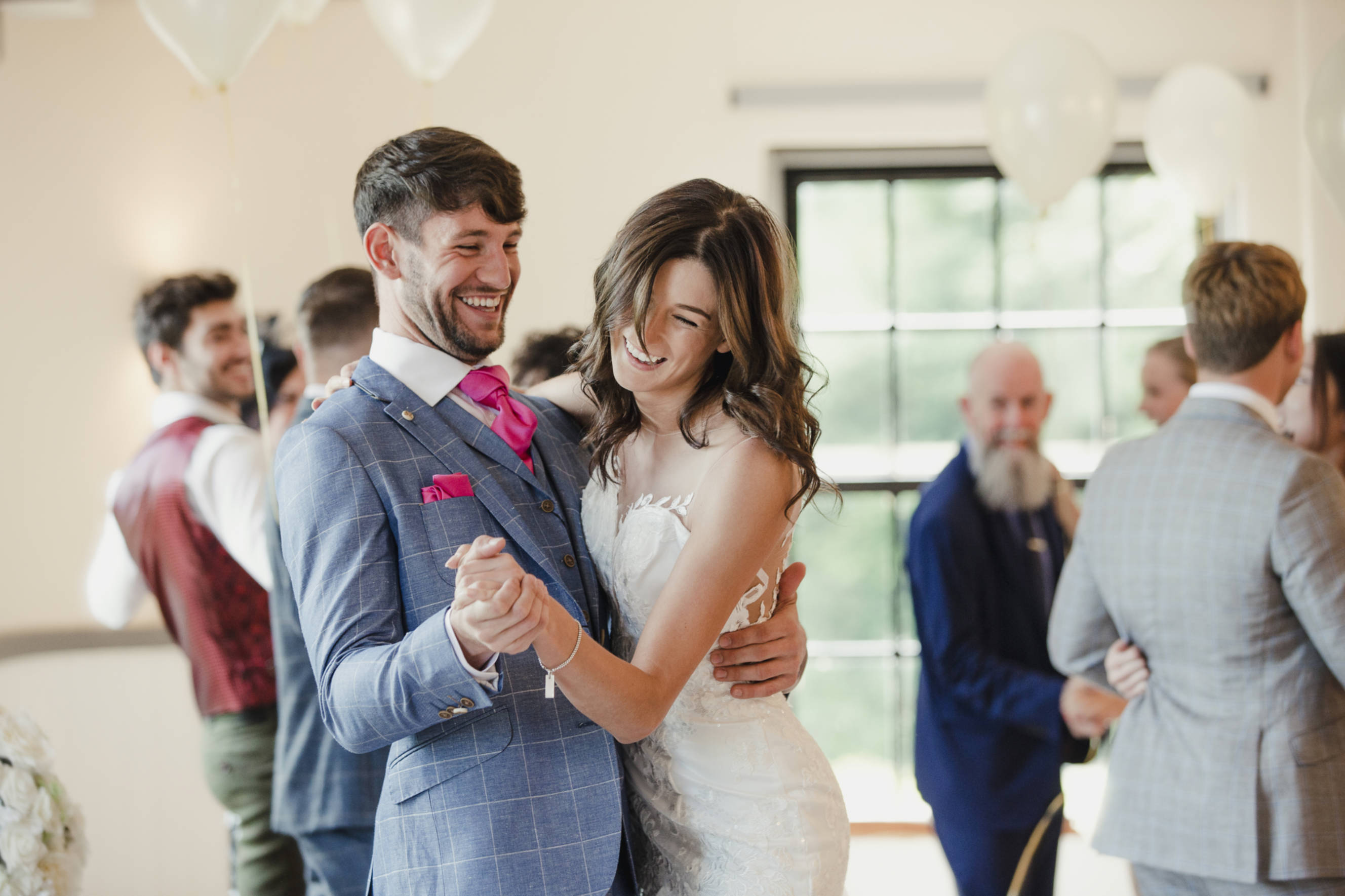 Bride and groom enjoying their first dance after taking wedding dancing lessons, smiling and celebrating during their reception.