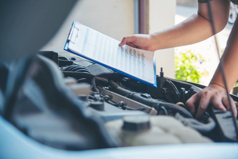 engine replacement cost - a mechanic diagnosing a car engine