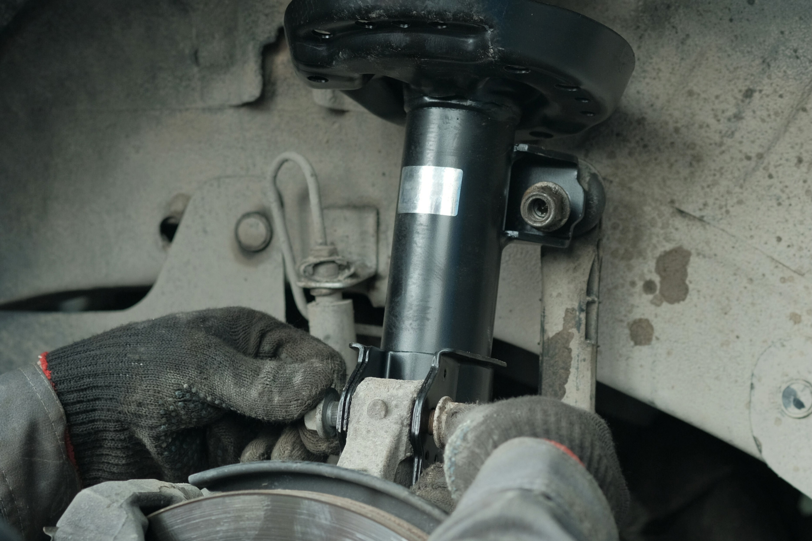 Mechanic repairing a car suspension system with precision, highlighting expert suspension repair specialists near you.