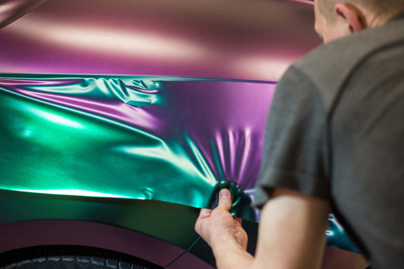 Professional installing a vibrant car wrap