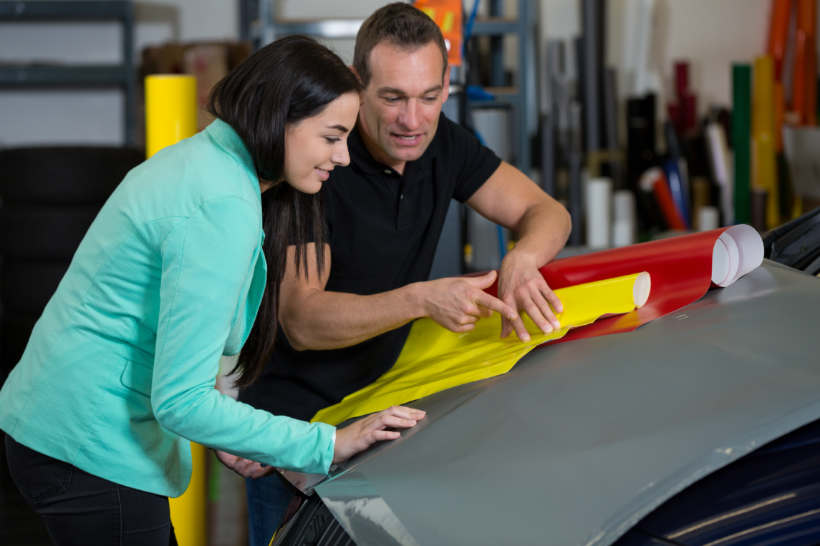 Two people discussing car wrap color options