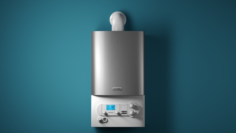 Electric boiler vs gas boiler - A sleek, modern electric boiler mounted on a teal wall