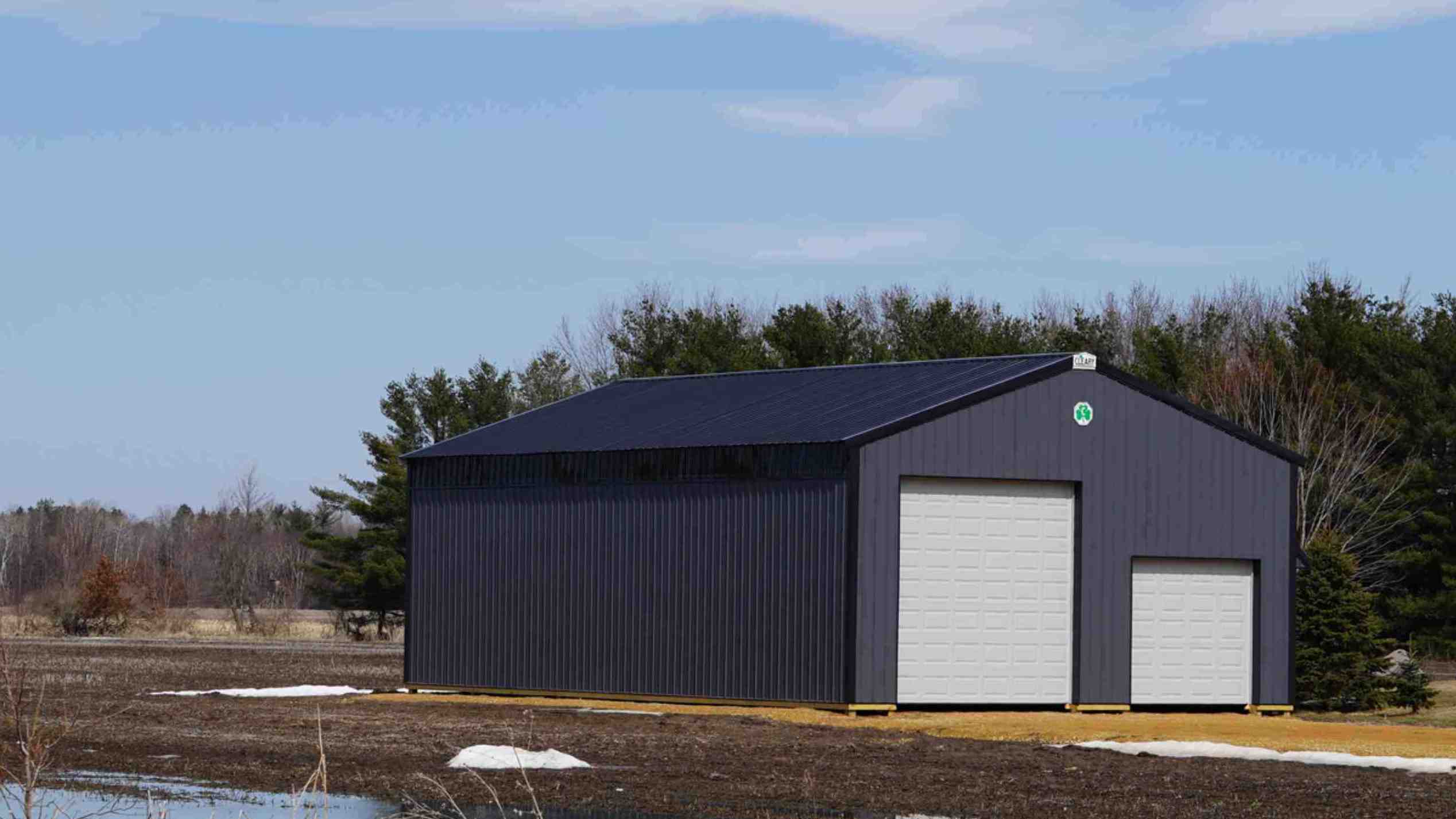 Barn vs shed - A durable steel barn designed for farm needs, featuring large open doors.