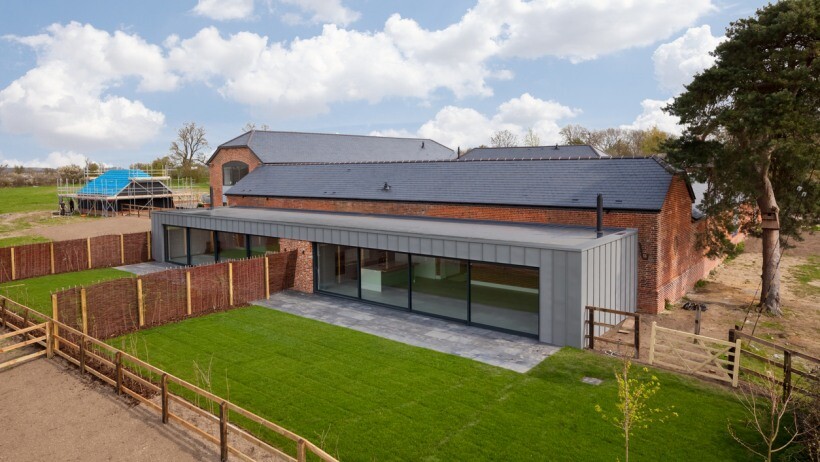 Barn vs shed - Modern barn conversion with large glass sliding doors and a sleek contemporary extension, blending rustic charm with modern architecture.