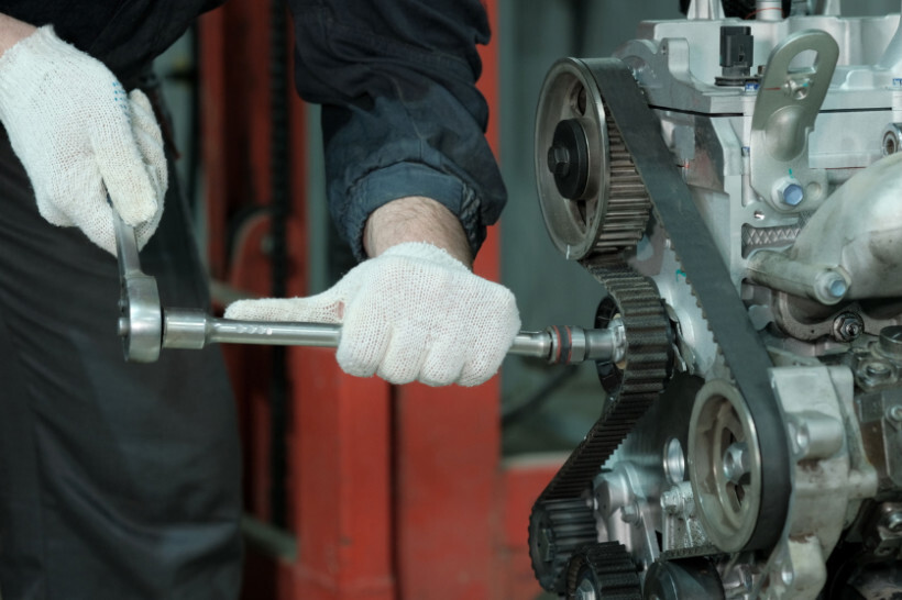 timing belt replacement cost - Mechanic in the process of replacing a timing belt