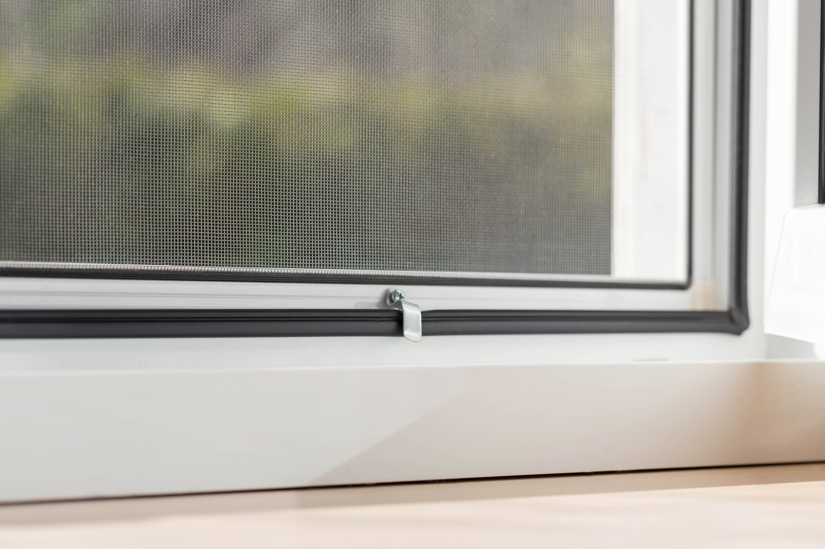 window screen installation - Close-up of a window screen latch on a newly installed screen.