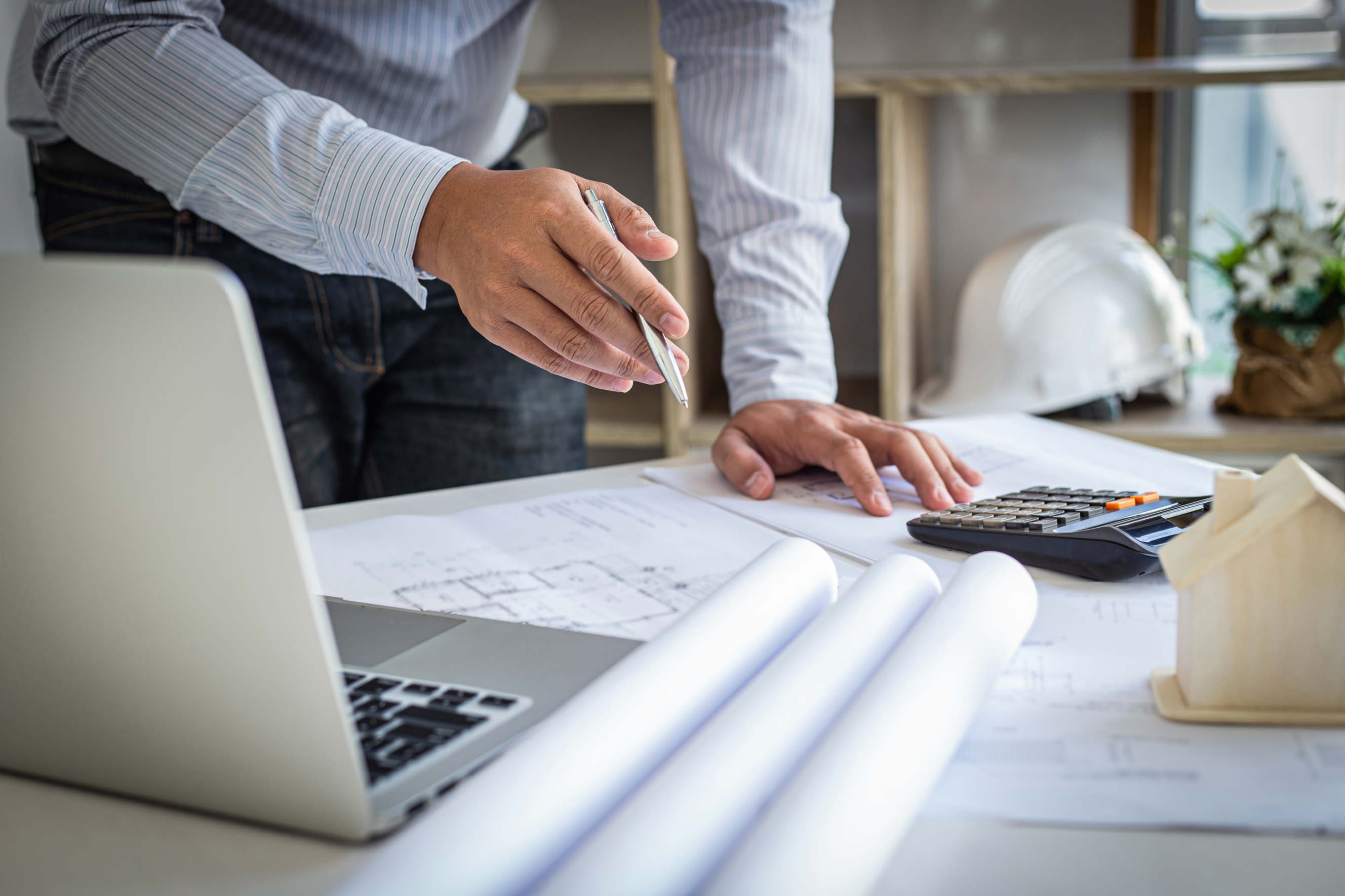 An architect analyzing blueprints and working on a technical AutoCAD design.