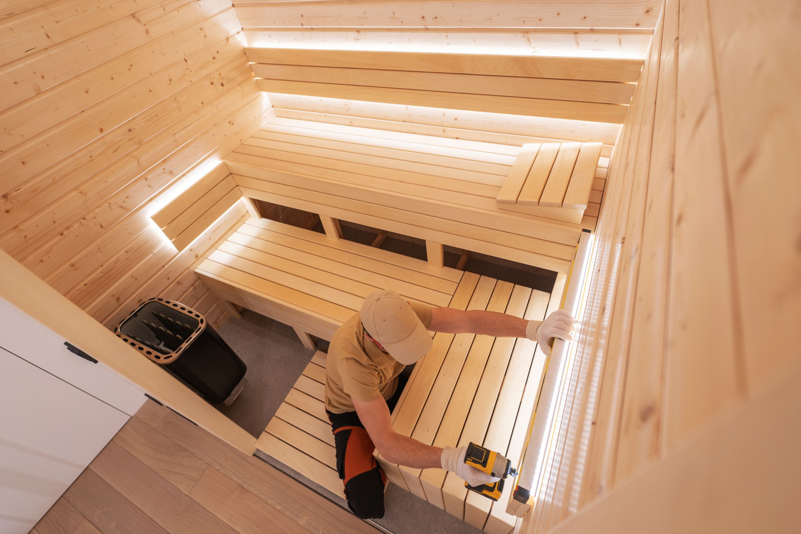 A professional spa builder in his 40s finishing residential sauna symbolizing sauna installation near me.