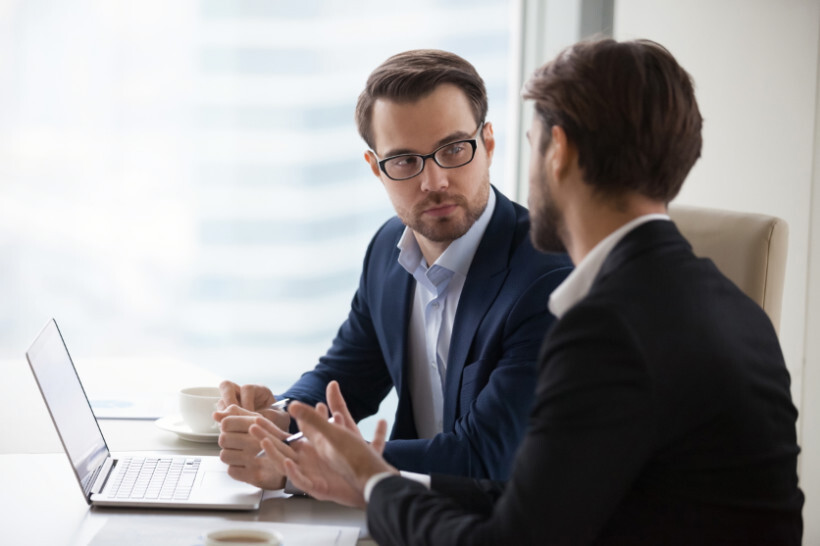 advisory-vs-consulting – male consultants in suits exchanging ideas during a formal business meeting