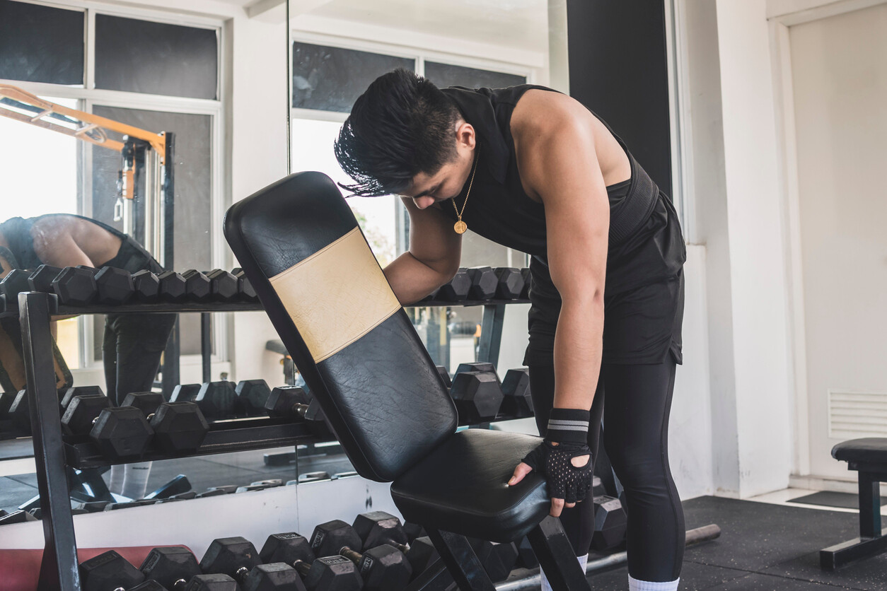 Gym equipment removals expert lifting and adjusting a workout bench in a fitness studio, preparing to move gym equipment safely and efficiently