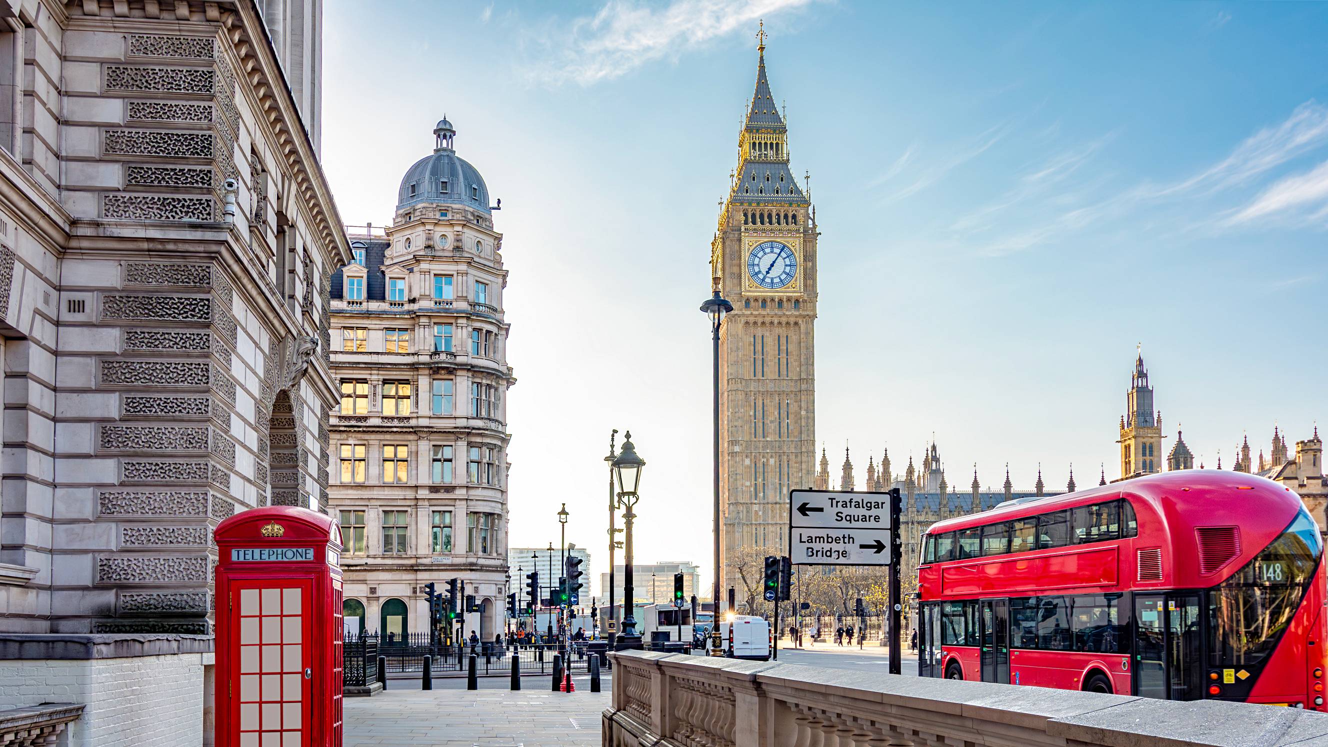 Classic London scene with Big Ben, a red telephone box, and a double-decker bus near Westminster