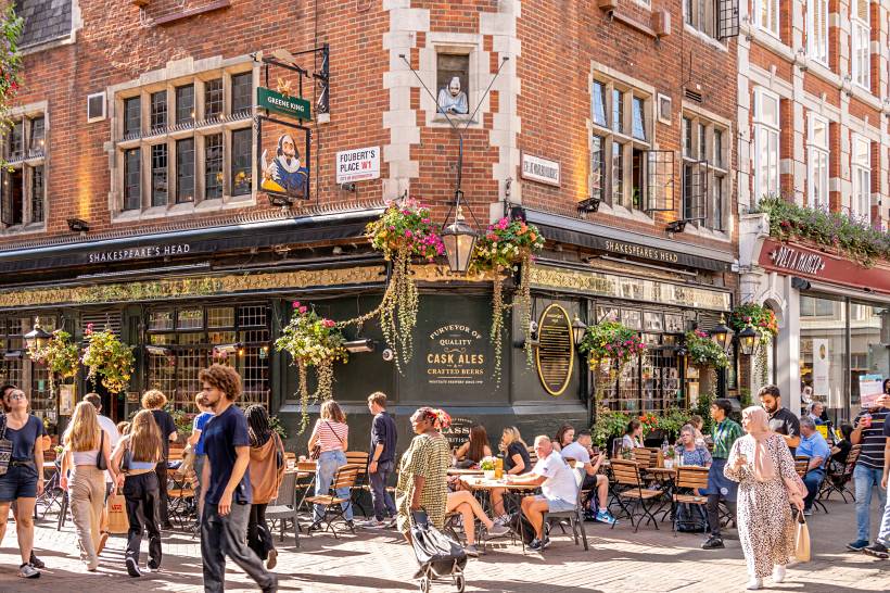 moving to London - People walking and dining outside the Shakespeare's Head pub in London’s Soho district