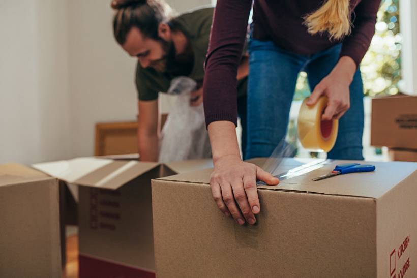 moving to London - Close-up of a couple packing cardboard boxes during a house move