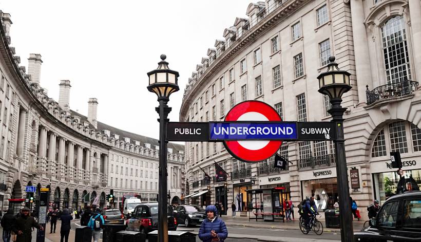 moving to London - View of the London Underground sign at Regent Street with people and traffic nearby