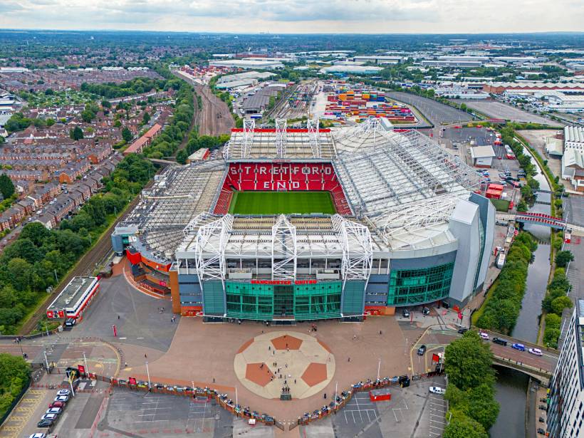 Aerial view of Old Trafford stadium, a key landmark for football fans moving to Manchester