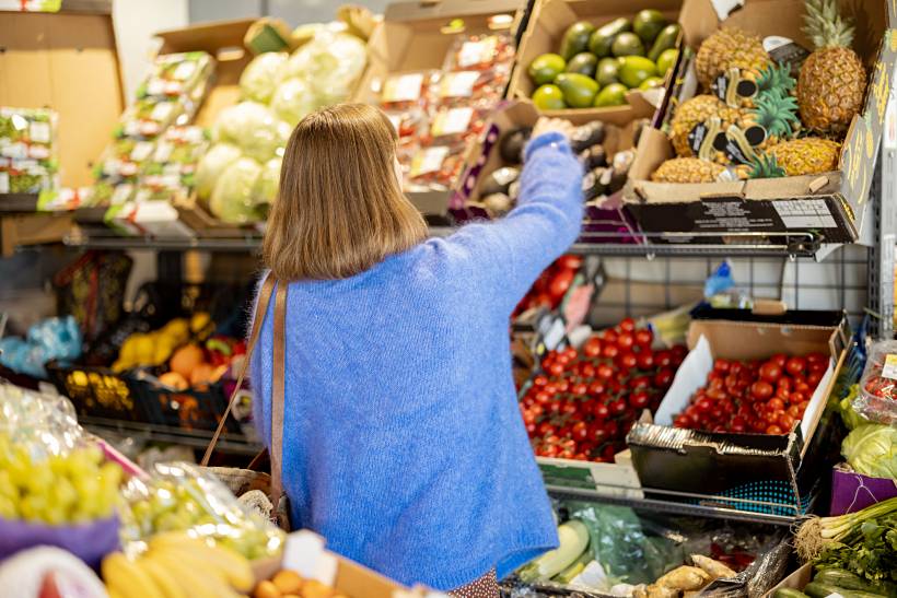 Woman selecting fresh produce at a local fruit and vegetable market in Liverpool