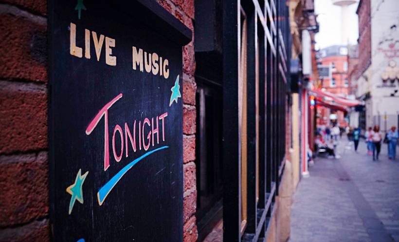 Narrow city street with a live music sign, representing Liverpool’s vibrant nightlife scene