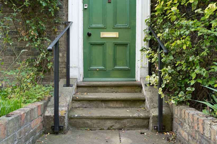 Green front door featuring a polished brass letterbox and matching door knocker. - how to replace a letterbox