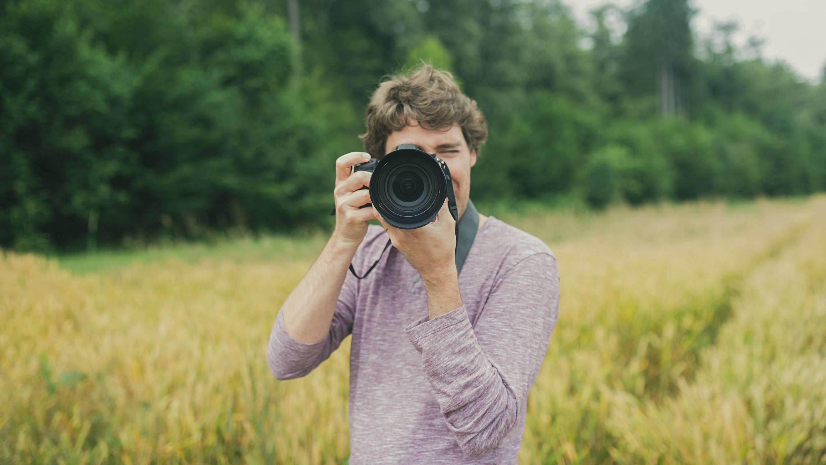 Young photographer standing in beautiful nature