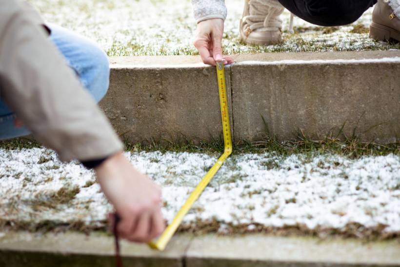 how to build garden steps - Garden step measurement in progress with a tape measure determining step height in an outdoor setting