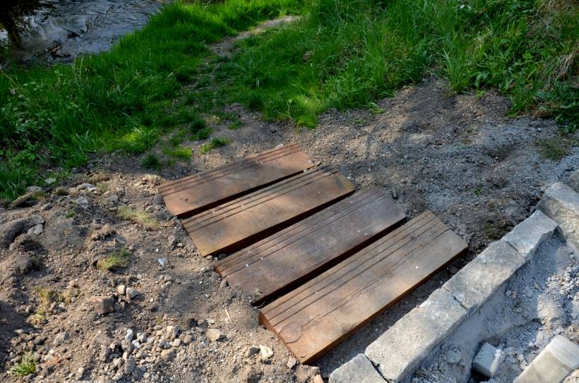 how to build garden steps - Garden steps in progress with wooden planks set into dirt on a sloped outdoor pathway