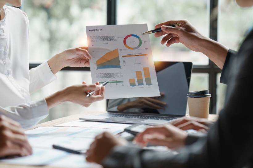 bookkeeper vs accountant - Financial data analysis meeting with business reports, charts, and performance metrics on display
