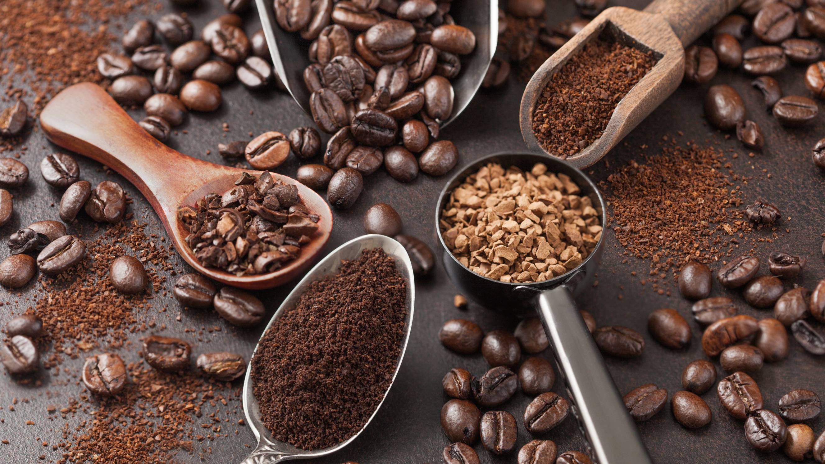 Whole coffee beans, ground coffee, and instant coffee displayed together