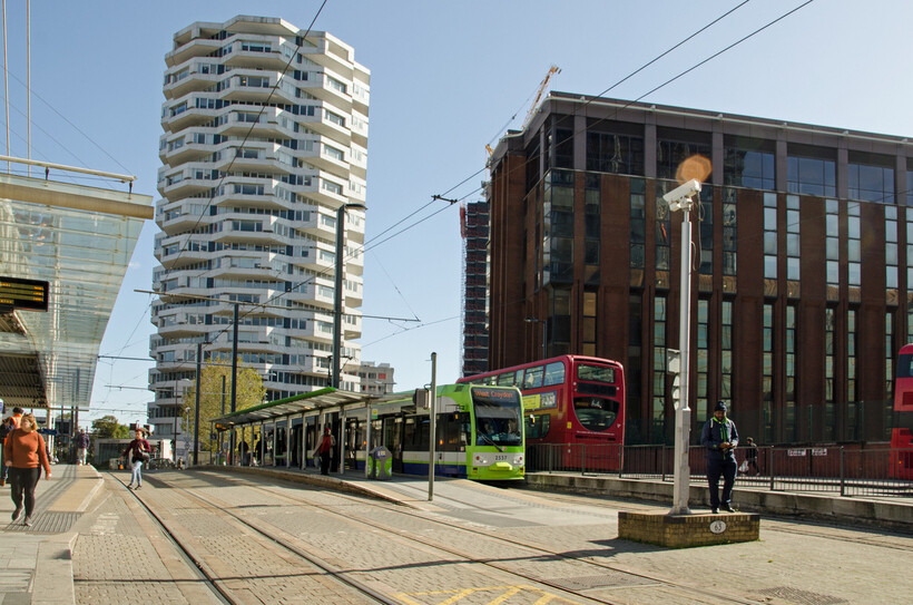 Travellers using tram and rail connections outside East Croydon station on a sunny day. - moving to Croydon