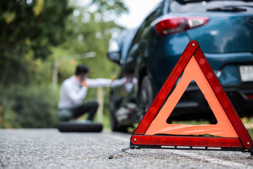 how much does a mobile mechanic cost - Driver calling a mobile mechanic beside a car stopped on the roadside