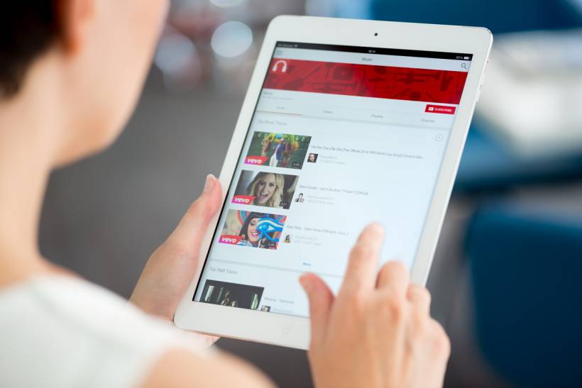 social media advertising cost - Person browsing online video content on a tablet