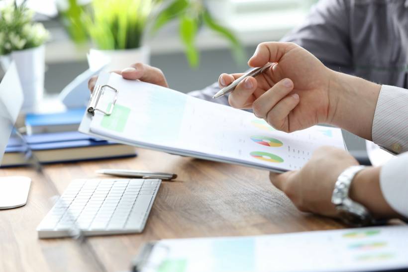 social media advertising cost - Business professionals reviewing charts and reports at a desk