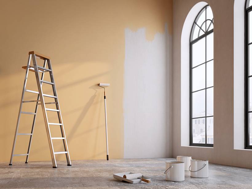 cost to paint interior of house - Painter’s ladder, roller and paint cans in sunlit room