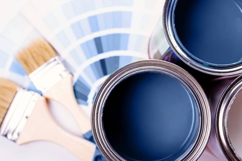 cost to paint interior of house - Open blue paint cans with brushes and colour swatches