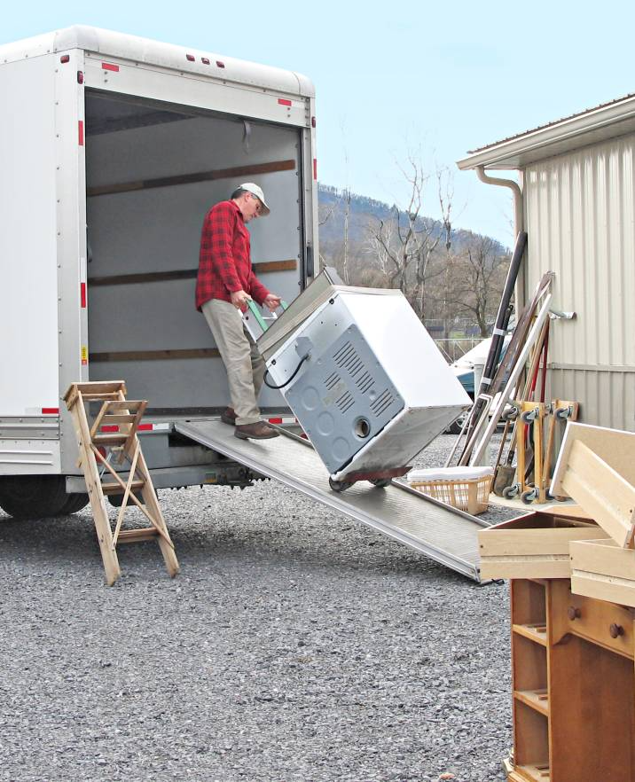 a furniture removalist loading a washing machine into a truck