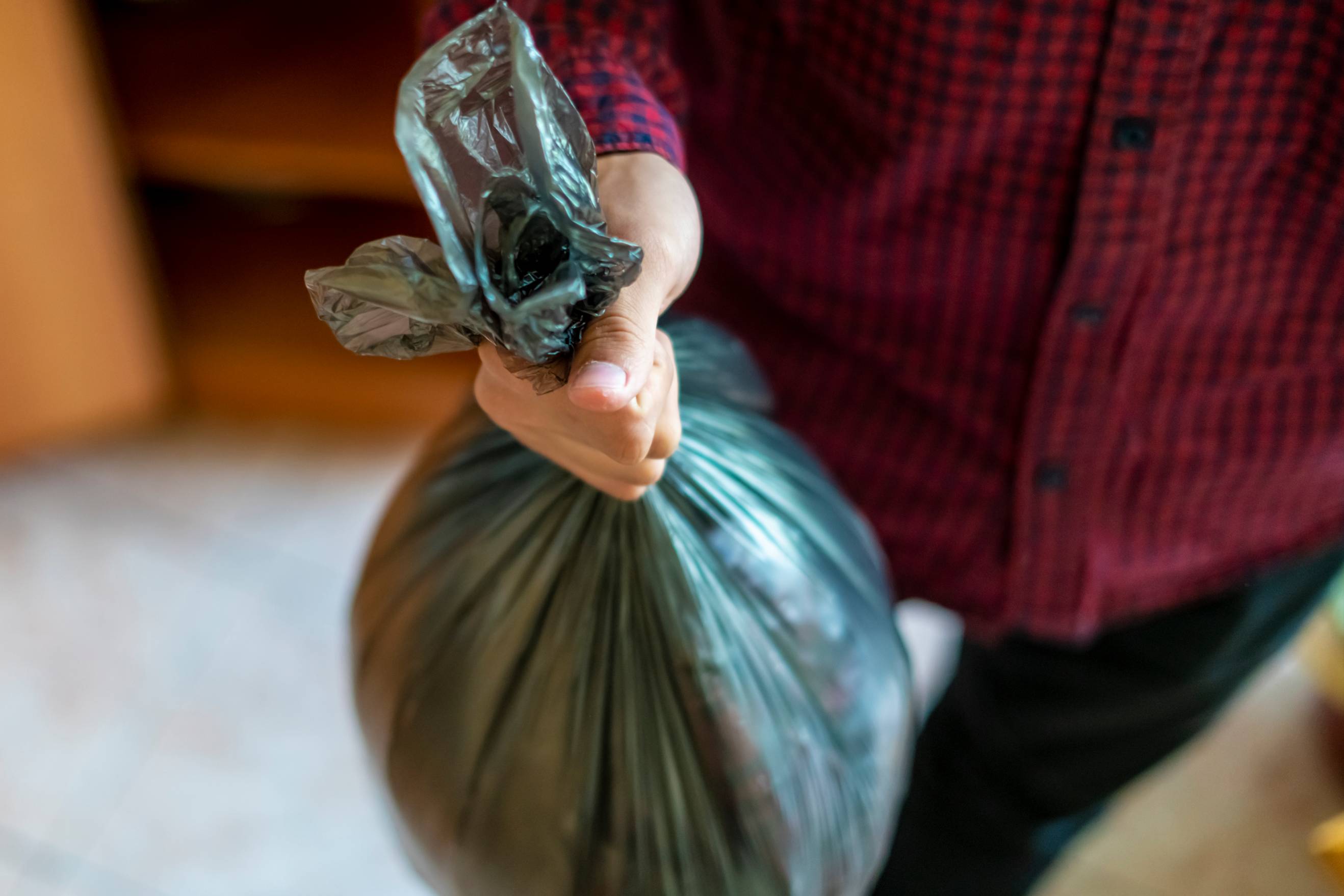 Tasker holding a waste bag for collection and disposal
