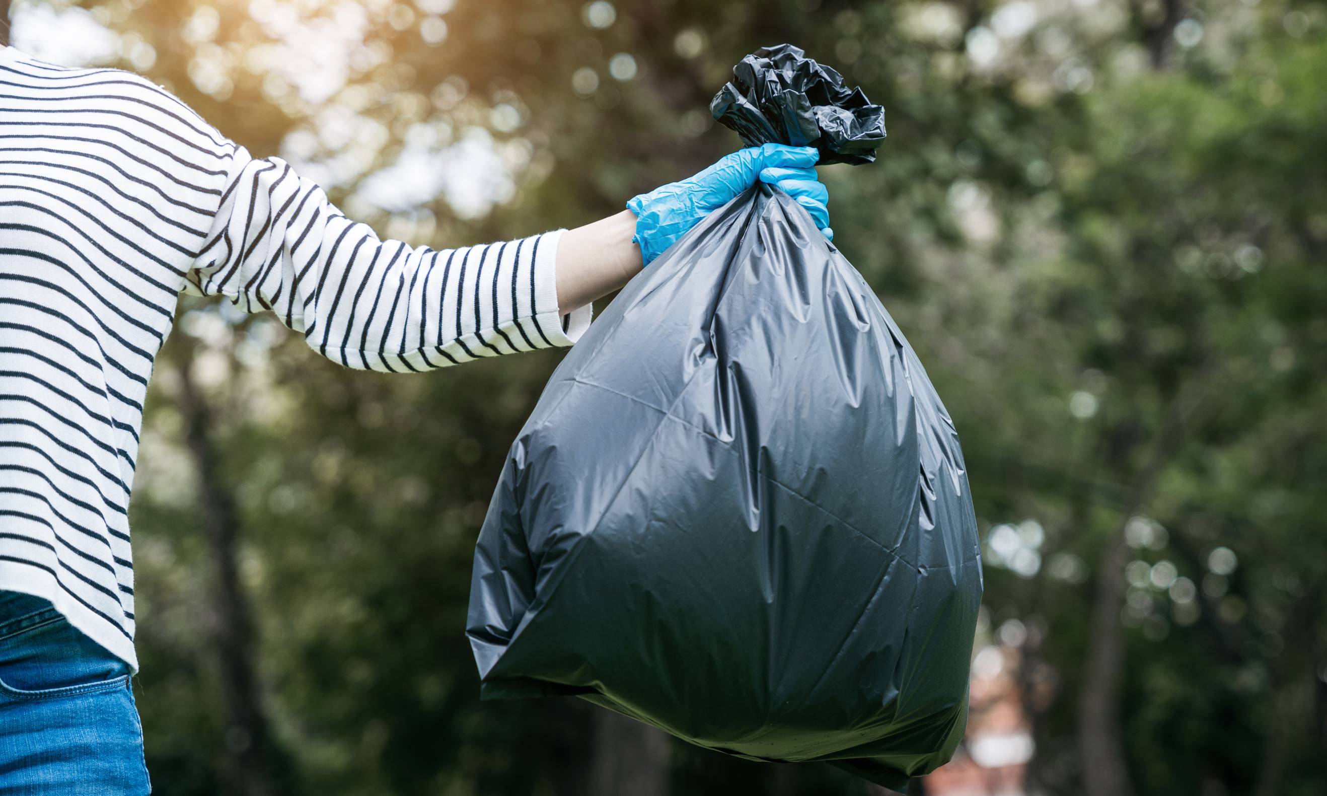 A person holding a bag with food waste for collection and disposal