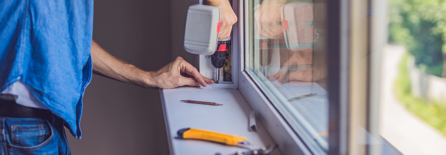 A handyman installing a new window.