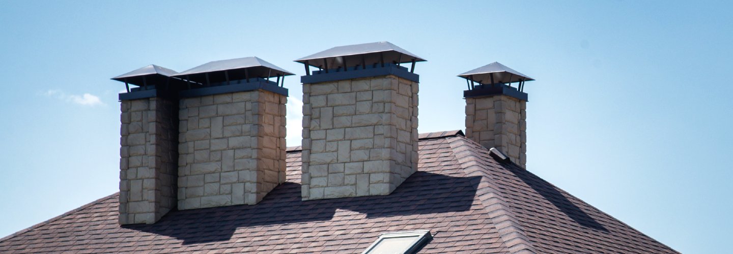 A close-up view of a roof with a ventilation system installed, showing metal vents and sunlight streaming through.