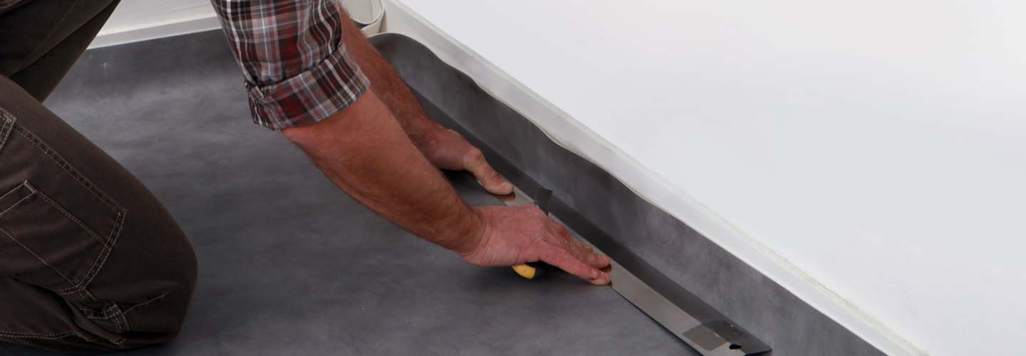 A close-up view of a linoleum flooring with a pattern of light and dark shades, creating a visually appealing and textured surface.