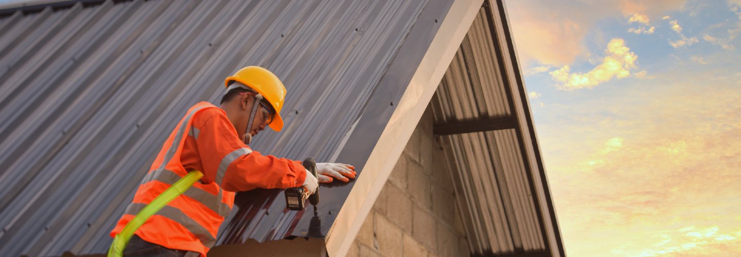 A worker installing a metal roof.
