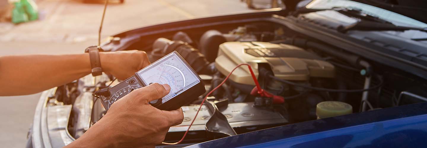 A mobile auto electrician working on a car, using specialized equipment, fixing electrical issues.