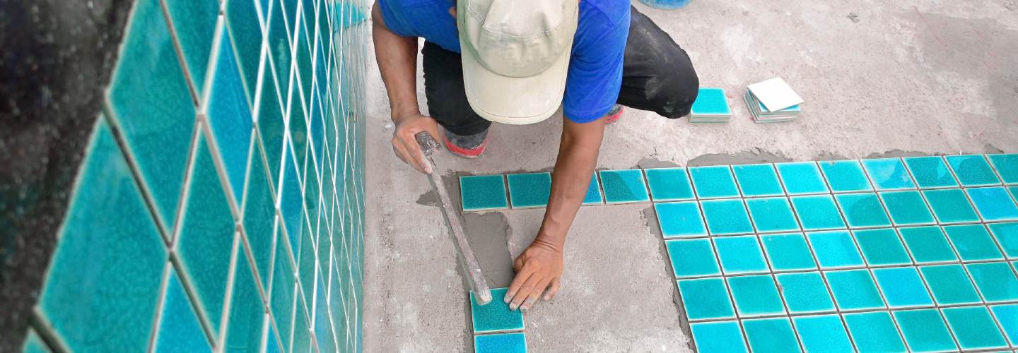 Working installing tiles on a pool.