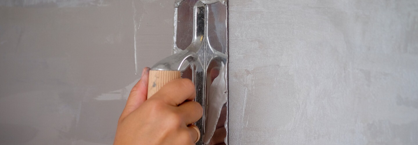 A close-up view of a wall with a textured Venetian plaster finish, showcasing a smooth and glossy surface with subtle variations in color.